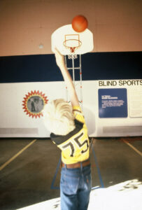 Sports equipment for the blind provided many meaningful interactive experiences. This blindfolded shooter aims for the hoop’s sound emitter.